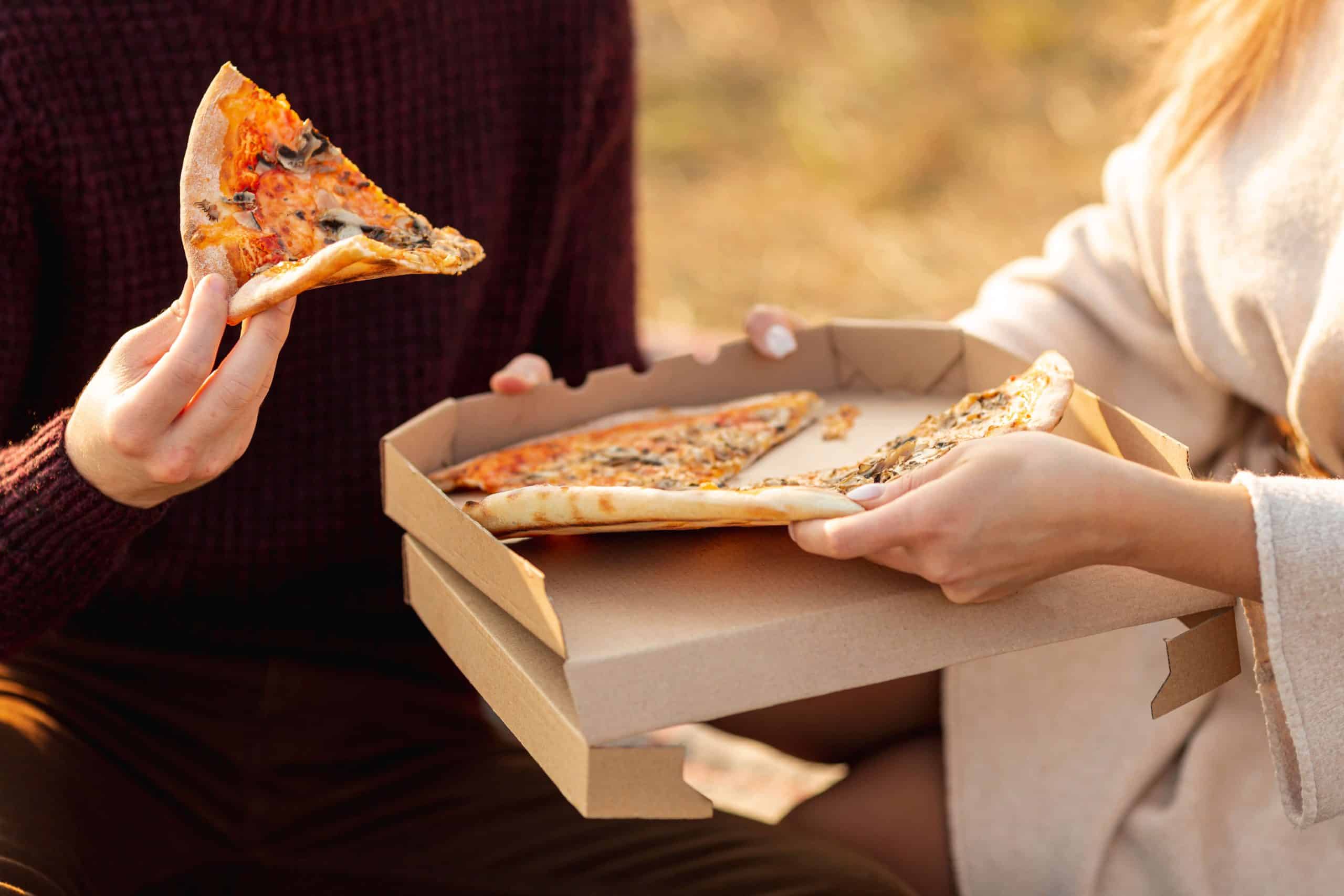 best-friends-enjoying-pizza-together-outside-close-up (1)